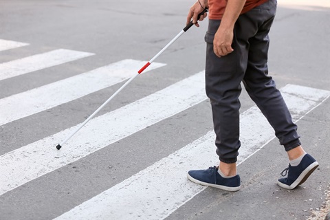 Man with cane crossing the street