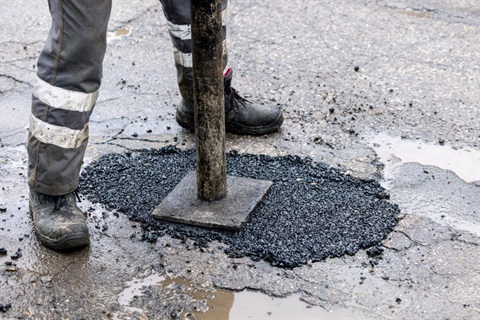 Person repairing a pothole