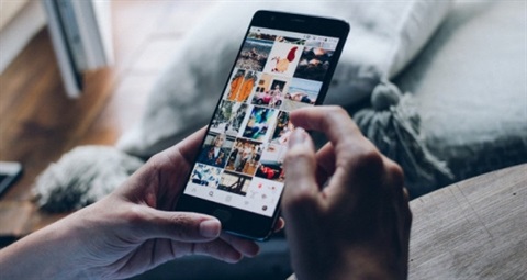 Person holding a phone displaying images