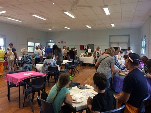 Market hall with lots of stalls and people enjoying Devonshire tea